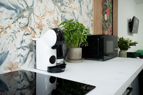 Kitchen with induction stove, microwave, fridge-freezer and cookware in Riga holiday apartment