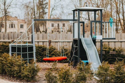 Children’s playground with swings and slide at Garden Apartments Riga, ideal for family stays